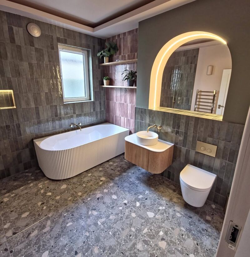 Loft bathroom with pink herringbone tiles and a skylight