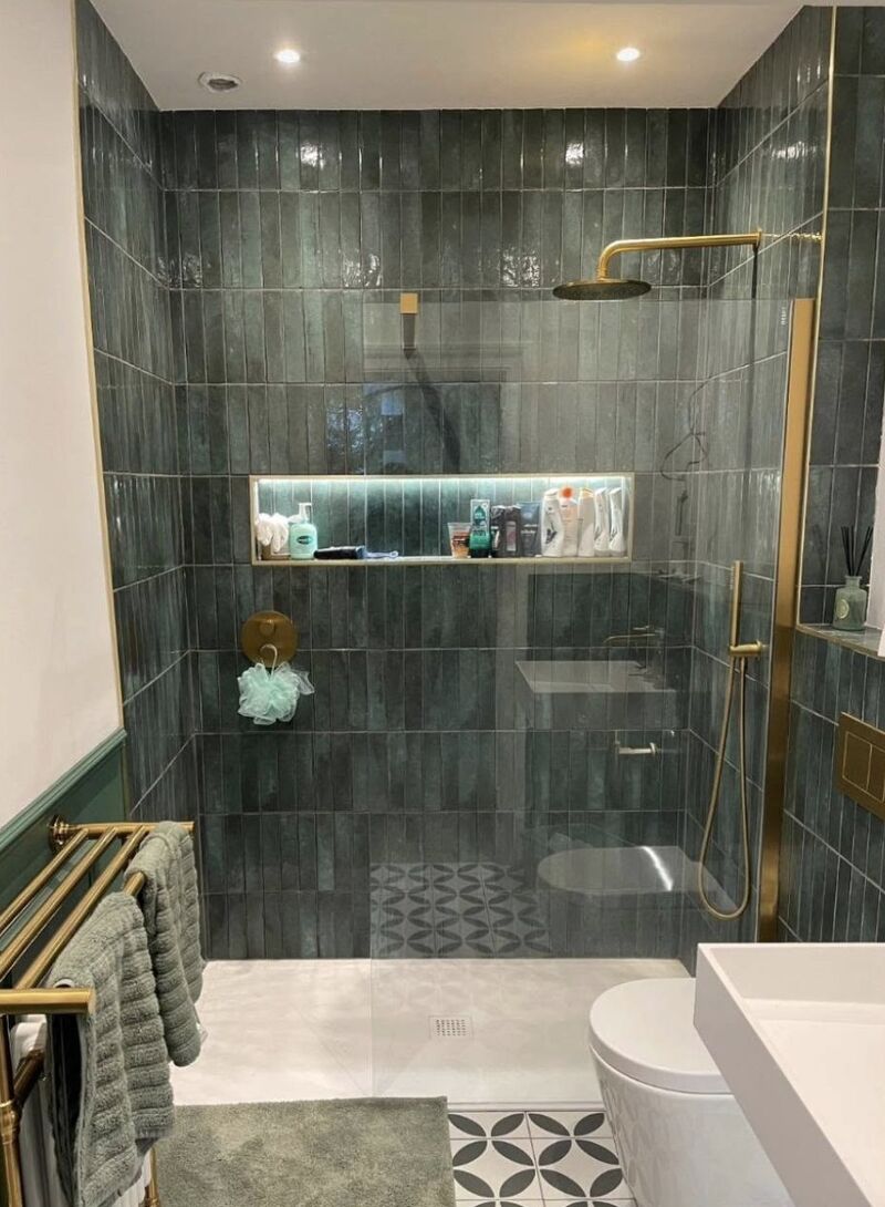 Walk-in shower with green glazed tiles and brass fittings