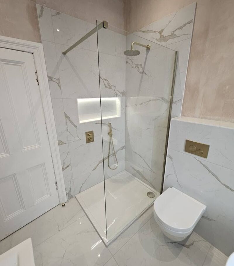 White marble-effect walk-in shower with brushed brass fittings